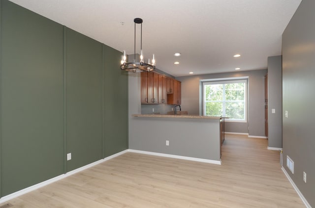 8397 Norwood Ln N, Maple Grove, MN 55311 - kitchen featuring a chandelier, light wood finished floors, brown cabinets, a peninsula, and recessed lighting