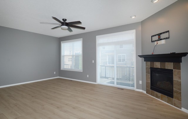 8397 Norwood Ln N, Maple Grove, MN 55311 - unfurnished living room with light wood-style floors, a ceiling fan, and a fireplace