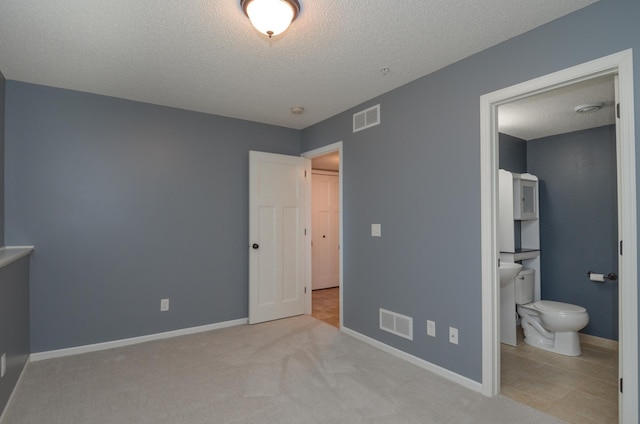 8397 Norwood Ln N, Maple Grove, MN 55311 - unfurnished bedroom with a textured ceiling, ensuite bath, and carpet floors