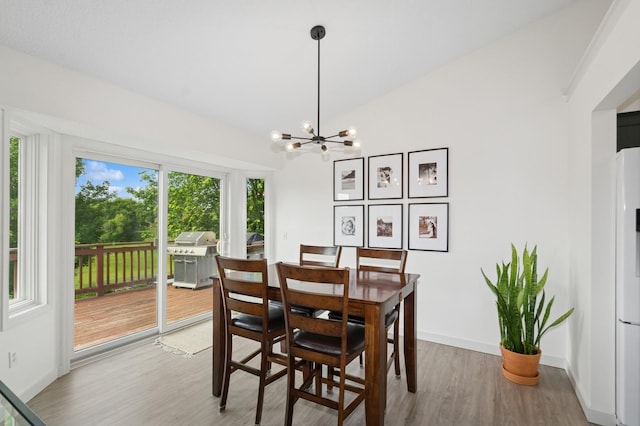 409 Birch Ave NW, Saint Michael, MN 55376 - dining area with light wood-style floors, a chandelier, and vaulted ceiling