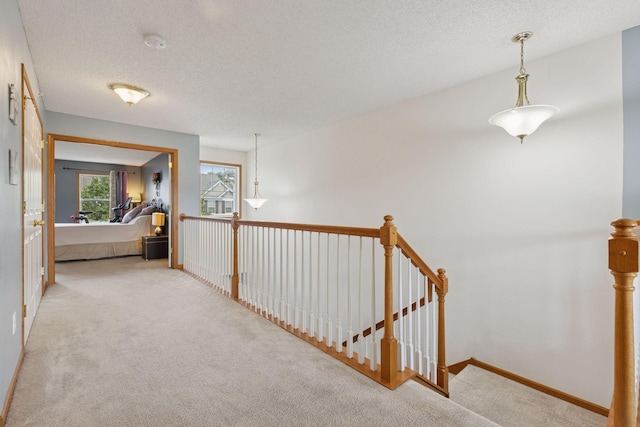 7308 Unity Ln N, Brooklyn Park, MN 55443 - corridor with carpet floors, a textured ceiling, and an upstairs landing