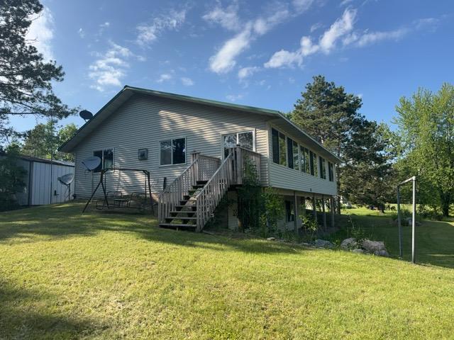 7300 County Road 8 NE, Longville, MN 56655 - rear view of house with a yard, stairs, and a wooden deck