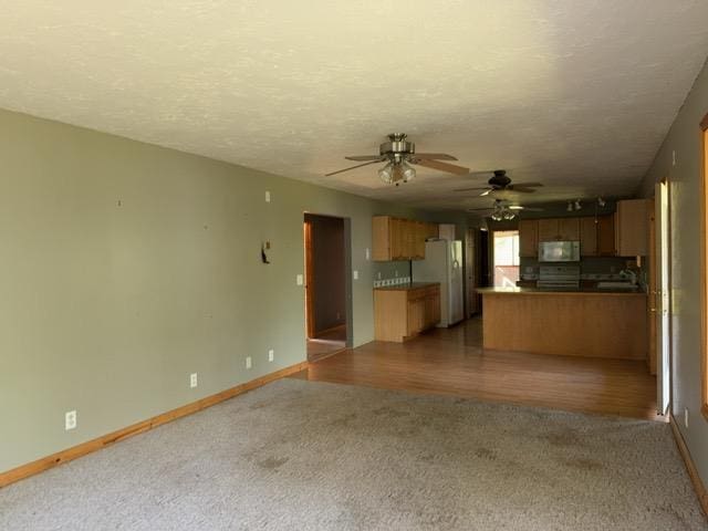 7300 County Road 8 NE, Longville, MN 56655 - kitchen with carpet floors, white appliances, open floor plan, a peninsula, and ceiling fan
