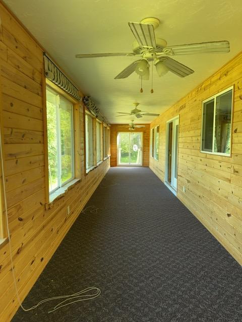 7300 County Road 8 NE, Longville, MN 56655 - unfurnished sunroom with wood walls and carpet flooring
