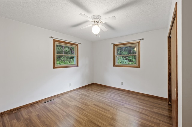 14476 261st Ave NW, Orrock Twp, MN 55398 - unfurnished bedroom with light wood finished floors, a textured ceiling, ceiling fan, and a closet