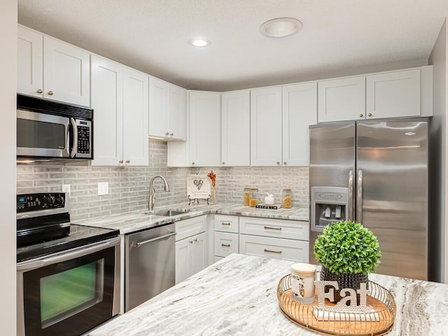 1181 Yuma Ln N, Plymouth, MN 55447 - kitchen featuring appliances with stainless steel finishes, light stone counters, white cabinetry, backsplash, and recessed lighting