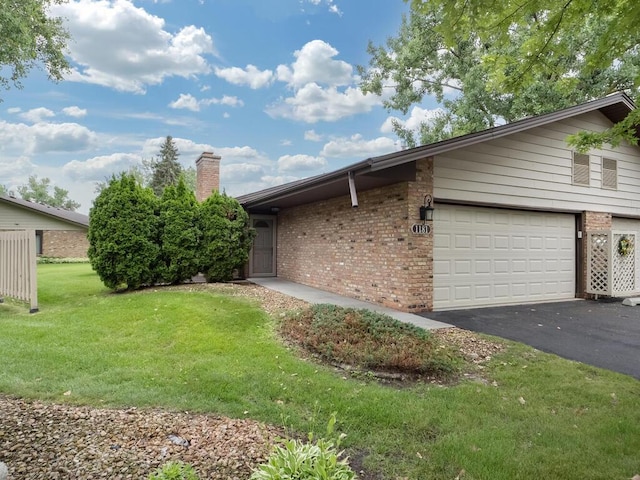 1181 Yuma Ln N, Plymouth, MN 55447 - view of side of property with brick siding, asphalt driveway, a chimney, and a yard