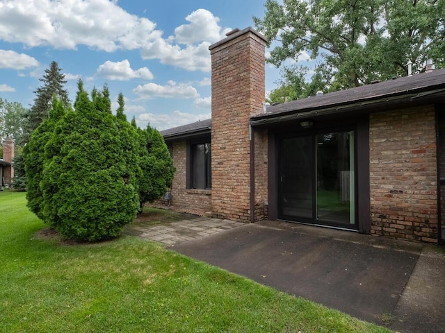 1181 Yuma Ln N, Plymouth, MN 55447 - back of property with a chimney, a patio, brick siding, and a lawn