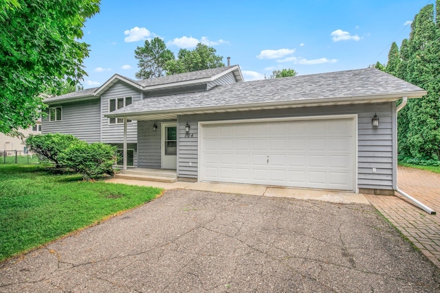 104 9th Ave N, Sartell, MN 56377 - tri-level home with a front yard, driveway, roof with shingles, and a garage