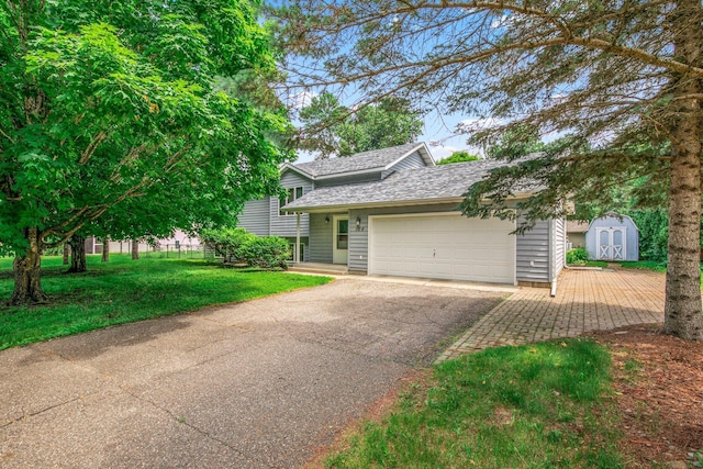 104 9th Ave N, Sartell, MN 56377 - view of front of house featuring a shed, asphalt driveway, a garage, a shingled roof, and a front yard