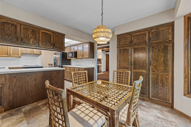 1267 Nursery Hill Ln, Arden Hills, MN 55112 - dining room with wallpapered walls, a chandelier, and stone finish floors