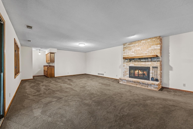 1267 Nursery Hill Ln, Arden Hills, MN 55112 - unfurnished living room with a textured ceiling, dark colored carpet, and a brick fireplace