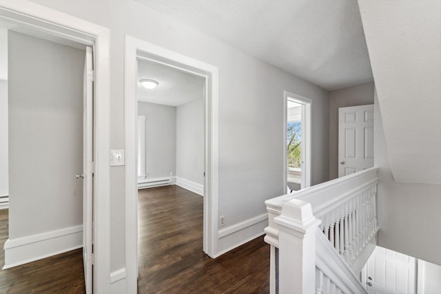 201 Genesee St, Saint Paul, MN 55117 - corridor with an upstairs landing, a baseboard radiator, dark wood-style flooring, and a textured ceiling