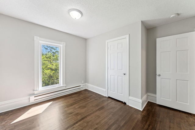 201 Genesee St, Saint Paul, MN 55117 - unfurnished bedroom with a baseboard heating unit, dark wood finished floors, and a textured ceiling