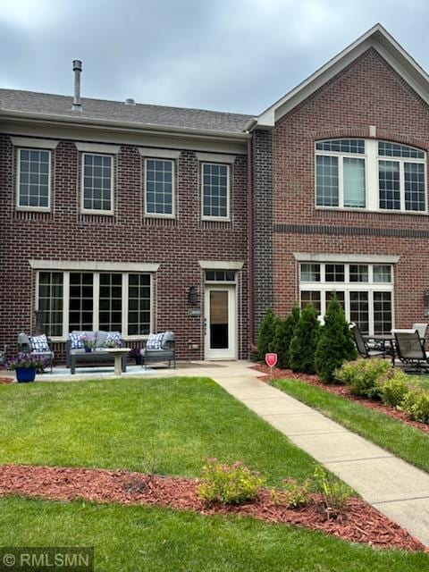 2460 119th Ct NE Unit D, Blaine, MN 55449 - rear view of property with brick siding, outdoor lounge area, a yard, and a patio