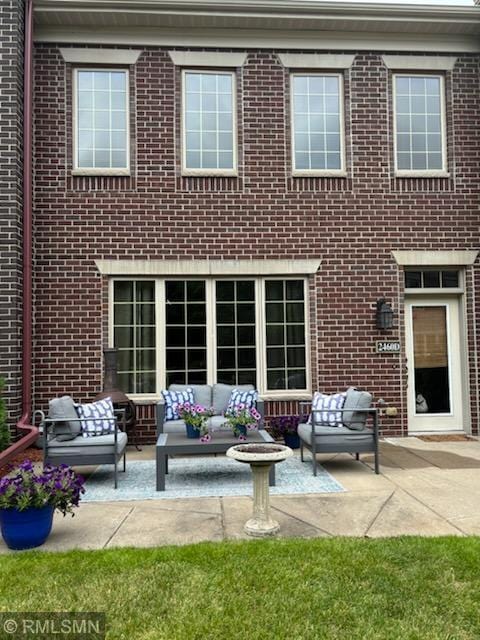 2460 119th Ct NE Unit D, Blaine, MN 55449 - back of property with an outdoor living space, a patio, and brick siding