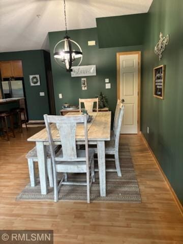 2460 119th Ct NE Unit D, Blaine, MN 55449 - dining space featuring a chandelier, light wood finished floors, and high vaulted ceiling
