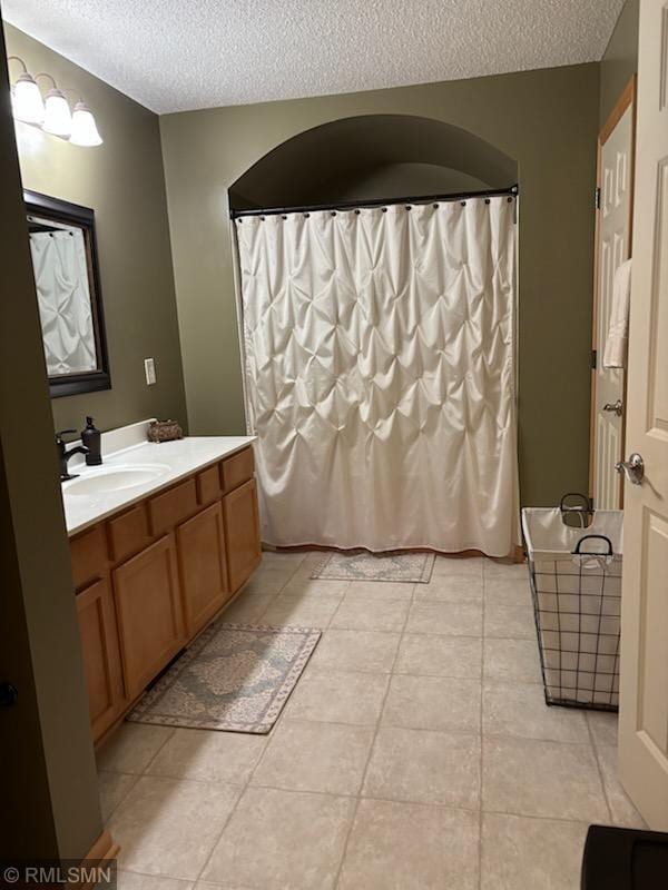 2460 119th Ct NE Unit D, Blaine, MN 55449 - full bathroom featuring a textured ceiling, vanity, tile patterned floors, and a shower with shower curtain