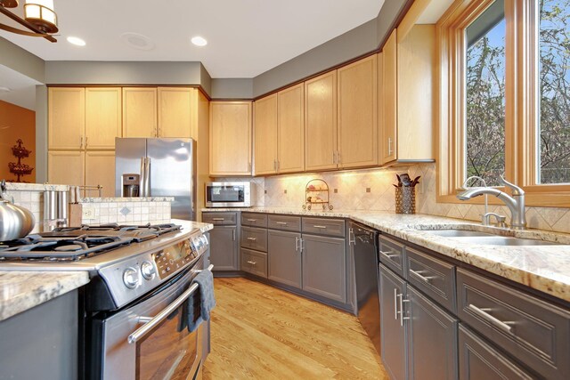 780 Virginia Shores Cir, Excelsior, MN 55331 - kitchen with appliances with stainless steel finishes, light wood-style floors, light stone counters, decorative backsplash, and recessed lighting