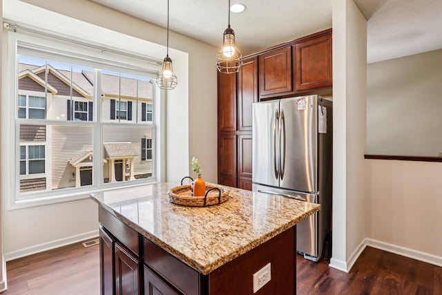8257 Norwood Ln N, Maple Grove, MN 55369 - kitchen featuring freestanding refrigerator, dark wood-style flooring, light stone counters, and a center island