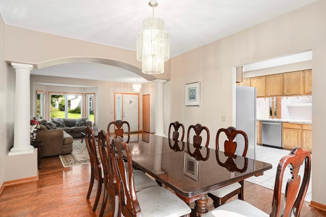 9035 Briarglen Rd, Eden Prairie, MN 55347 - dining room featuring arched walkways, decorative columns, light wood finished floors, and a chandelier