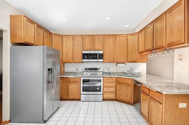 9035 Briarglen Rd, Eden Prairie, MN 55347 - kitchen featuring stainless steel appliances, a peninsula, tasteful backsplash, light tile patterned floors, and light stone counters