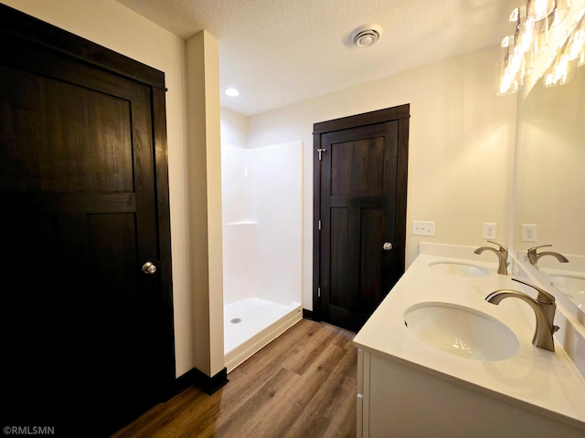 2101 Nelson St, Saint Peter, MN 56082 - full bath featuring wood finished floors, double vanity, and walk in shower