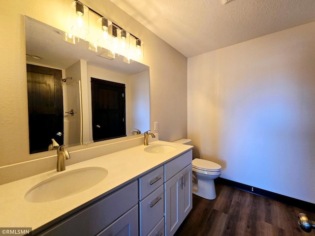 2101 Nelson St, Saint Peter, MN 56082 - bathroom featuring double vanity, wood finished floors, a textured ceiling, and a shower