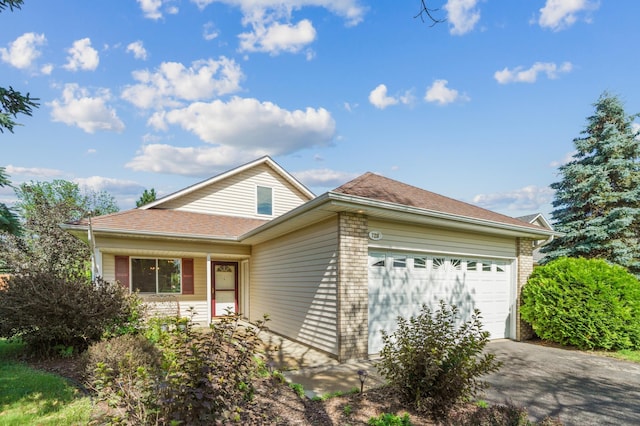 728 Elm St, Belle Plaine, MN 56011 - view of front of home featuring an attached garage, driveway, brick siding, and roof with shingles