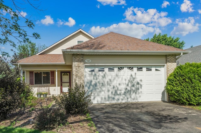 728 Elm St, Belle Plaine, MN 56011 - view of front of home with a garage, asphalt driveway, roof with shingles, and brick siding
