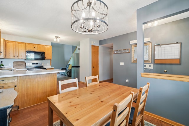 728 Elm St, Belle Plaine, MN 56011 - dining space with wood finished floors and a chandelier