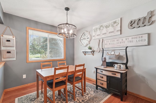 728 Elm St, Belle Plaine, MN 56011 - dining space featuring a chandelier, wood finished floors, and a textured ceiling