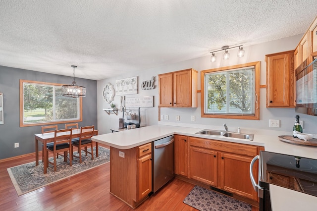 728 Elm St, Belle Plaine, MN 56011 - kitchen with stainless steel dishwasher, electric stove, a textured ceiling, a peninsula, and light countertops