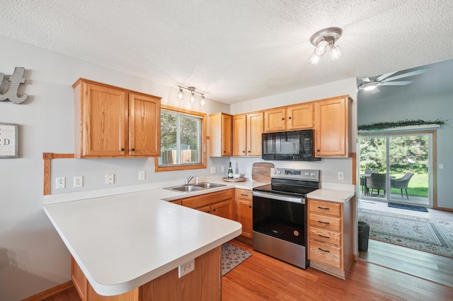 728 Elm St, Belle Plaine, MN 56011 - kitchen featuring black microwave, stainless steel electric range oven, a textured ceiling, a peninsula, and light countertops