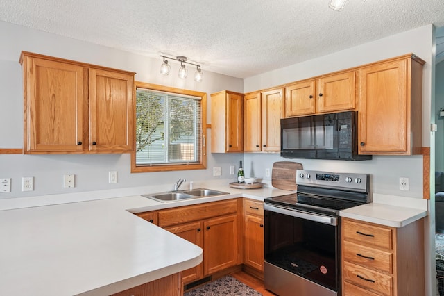 728 Elm St, Belle Plaine, MN 56011 - kitchen featuring black microwave, stainless steel range with electric cooktop, light countertops, a textured ceiling, and a peninsula