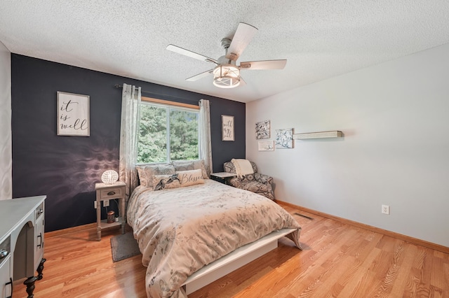 728 Elm St, Belle Plaine, MN 56011 - bedroom with light wood-type flooring, a textured ceiling, and a ceiling fan