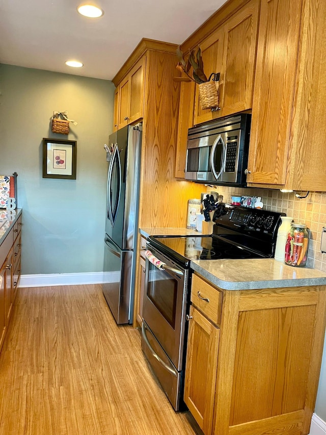 8412 4th Ave S, Bloomington, MN 55420 - kitchen featuring stainless steel appliances, brown cabinets, tasteful backsplash, light wood finished floors, and recessed lighting