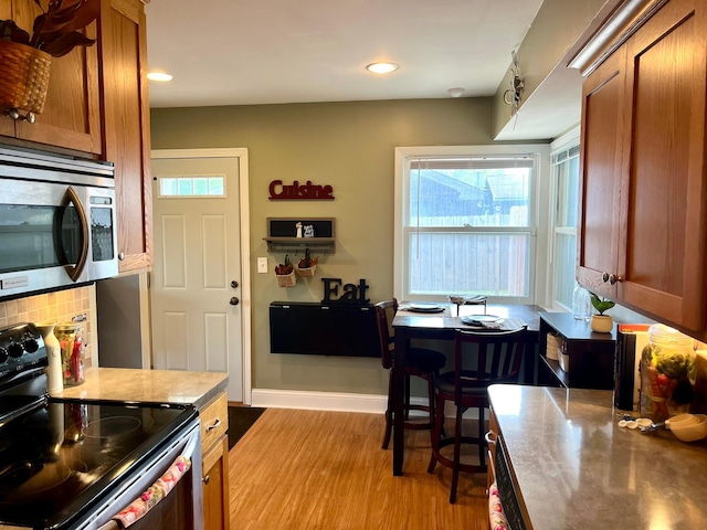 8412 4th Ave S, Bloomington, MN 55420 - kitchen featuring electric stove, stainless steel microwave, brown cabinetry, plenty of natural light, and recessed lighting