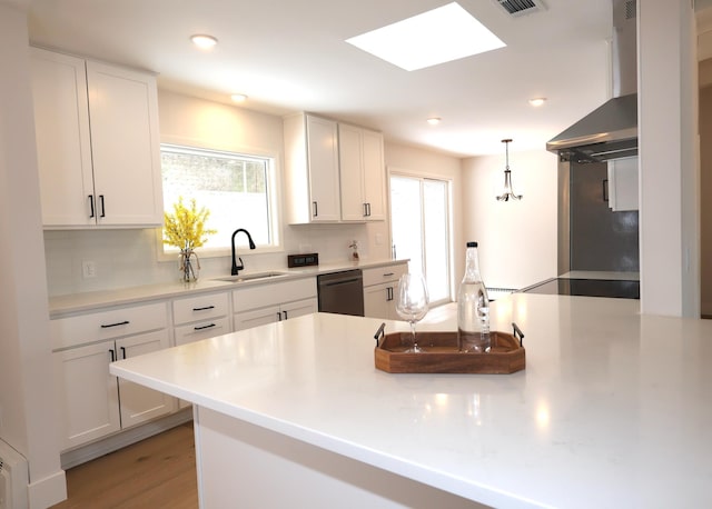 2611 Kyle Ave N, Golden Valley, MN 55422 - kitchen with dishwashing machine, wall chimney range hood, backsplash, white cabinets, and light countertops