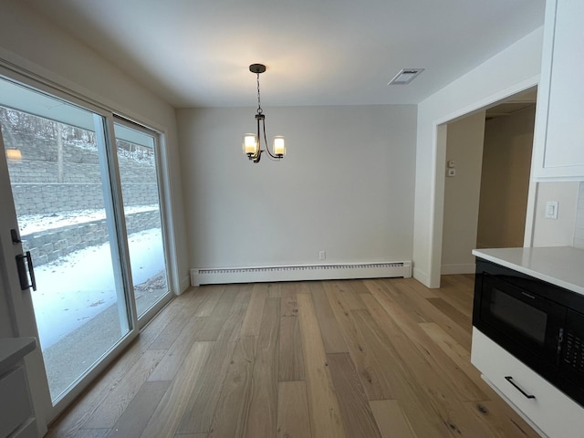 2611 Kyle Ave N, Golden Valley, MN 55422 - unfurnished dining area with a baseboard radiator, light wood-style flooring, and a chandelier