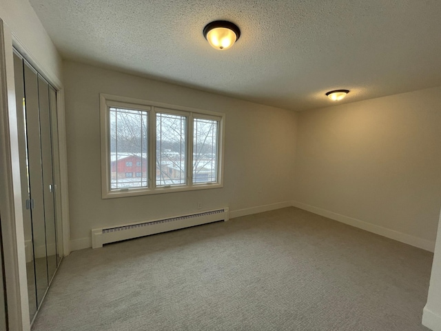2611 Kyle Ave N, Golden Valley, MN 55422 - unfurnished bedroom featuring a baseboard heating unit, a textured ceiling, light carpet, and a closet