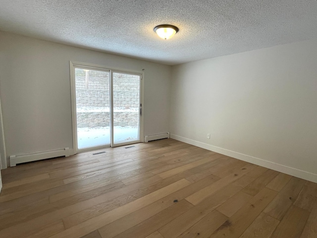 2611 Kyle Ave N, Golden Valley, MN 55422 - spare room featuring baseboard heating, light wood-style floors, and a textured ceiling