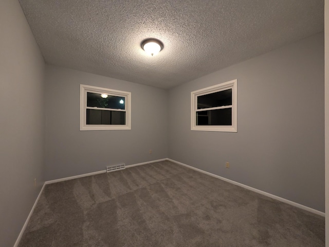 507 1st St, Marshall, MN 56258 - spare room with dark carpet and a textured ceiling