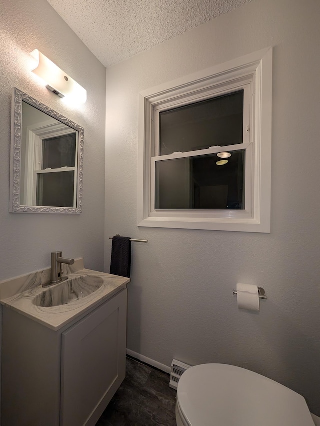507 1st St, Marshall, MN 56258 - bathroom featuring vanity, a textured ceiling, and a baseboard radiator