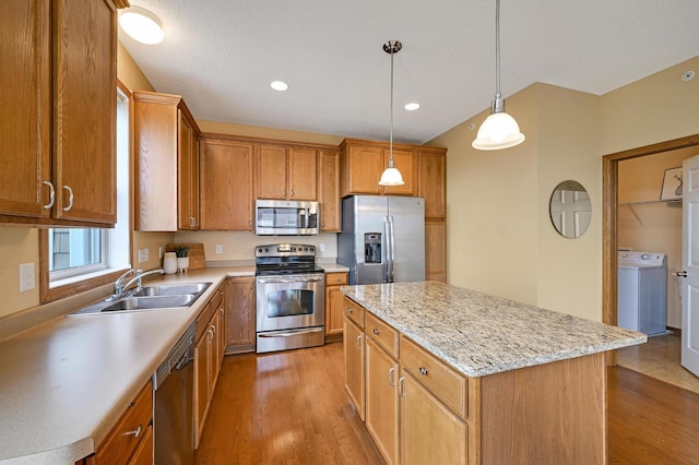 16618 72nd Ct NE, Otsego, MN 55330 - kitchen with appliances with stainless steel finishes, washer / dryer, wood finished floors, a kitchen island, and recessed lighting