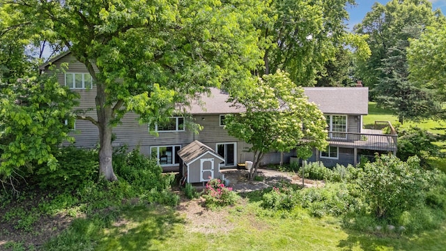 940 Brown Rd S, Wayzata, MN 55391 - rear view of property with a storage unit, a wooden deck, a chimney, and a shingled roof