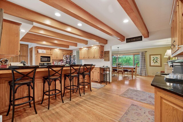 940 Brown Rd S, Wayzata, MN 55391 - kitchen with black appliances, a kitchen bar, beam ceiling, light wood-type flooring, and recessed lighting