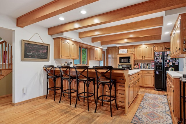 940 Brown Rd S, Wayzata, MN 55391 - kitchen with black appliances, a peninsula, light wood finished floors, a breakfast bar, and beam ceiling