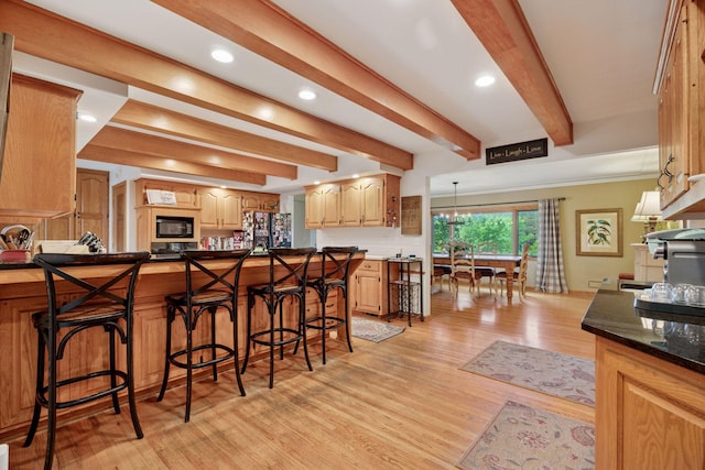 940 Brown Rd S, Wayzata, MN 55391 - kitchen featuring black appliances, a breakfast bar area, beamed ceiling, light wood-style flooring, and recessed lighting