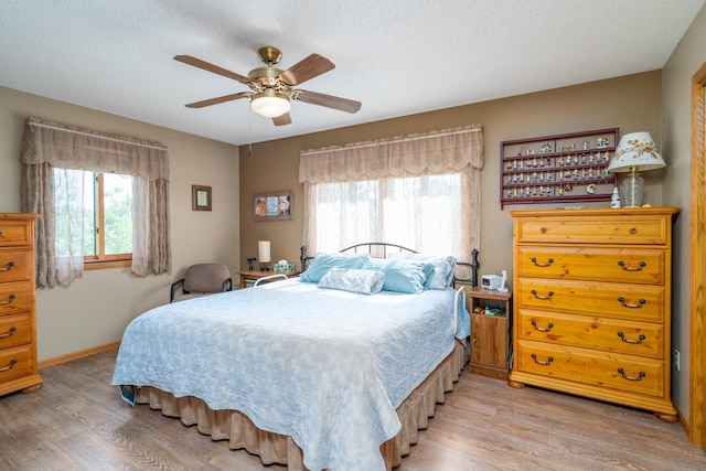350 3rd St NE, Mcintosh, MN 56556 - bedroom featuring light wood-style floors, a textured ceiling, and a ceiling fan